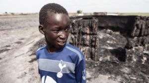 燃え尽きた自宅前で佇む子ども 2015年5月23日 ©CC BY-NC-ND / ICRC / P. Krzysiek