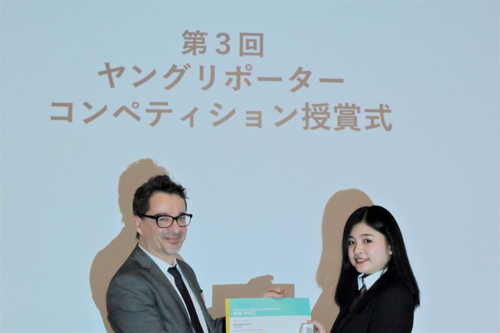 ICRC駐日代表レジス・サビオよりICRC賞の賞状とトロフィーを受け取る石田さん（右）