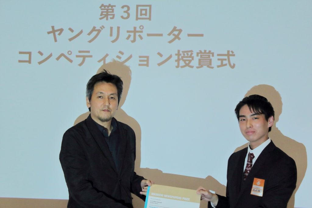 毎日新聞社の佐藤賢二郎氏より表彰される佐々木さん（右）