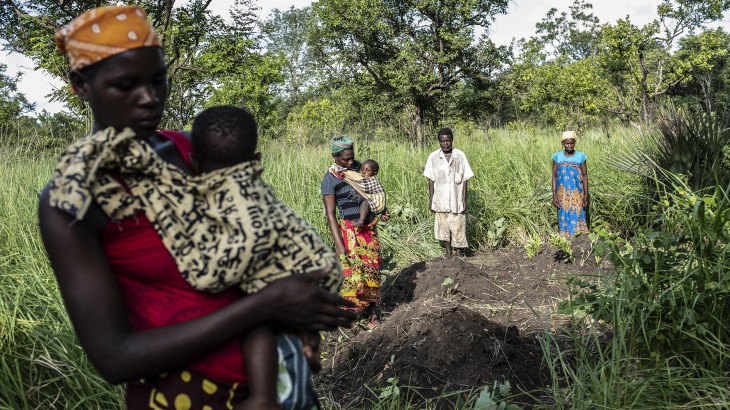  2019年3月に発生したサイクロンで亡くなった身内の墓参りに訪れる家族。犠牲者は納体袋に納められ集団墓地に埋葬された（モザンビーク）