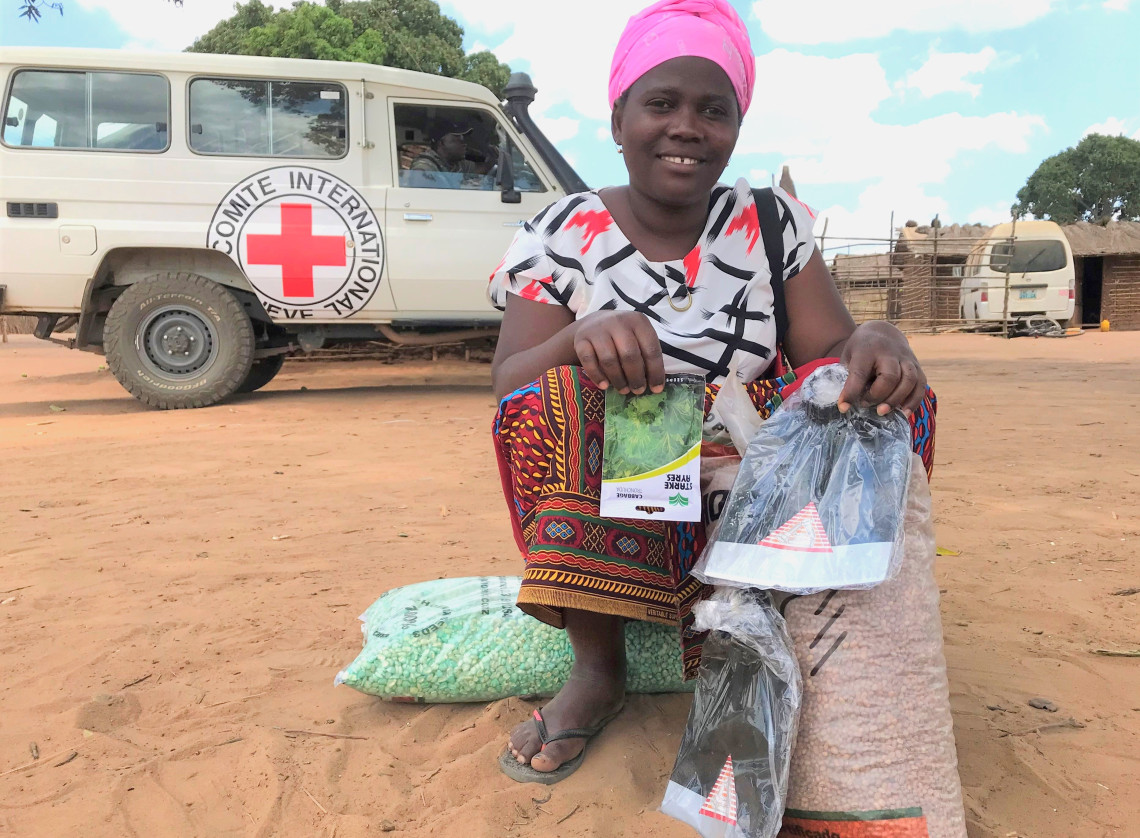 ICRCの車を背に微笑む支援物資を受け取った女性