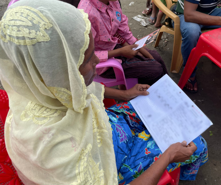 椅子に座り息子から届いた手紙を読む母親