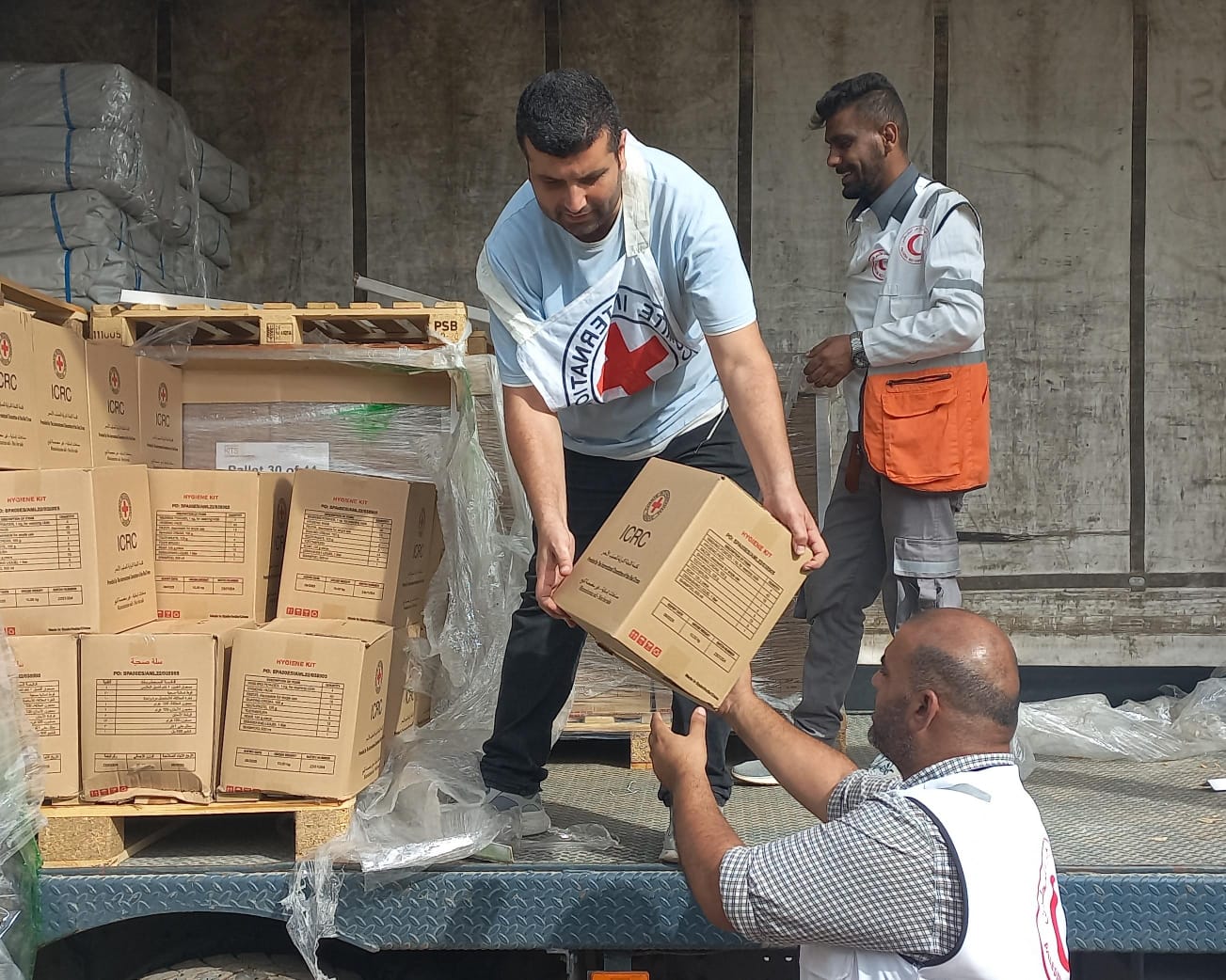 現地に到着した緊急支援物資を運ぶICRCスタッフ