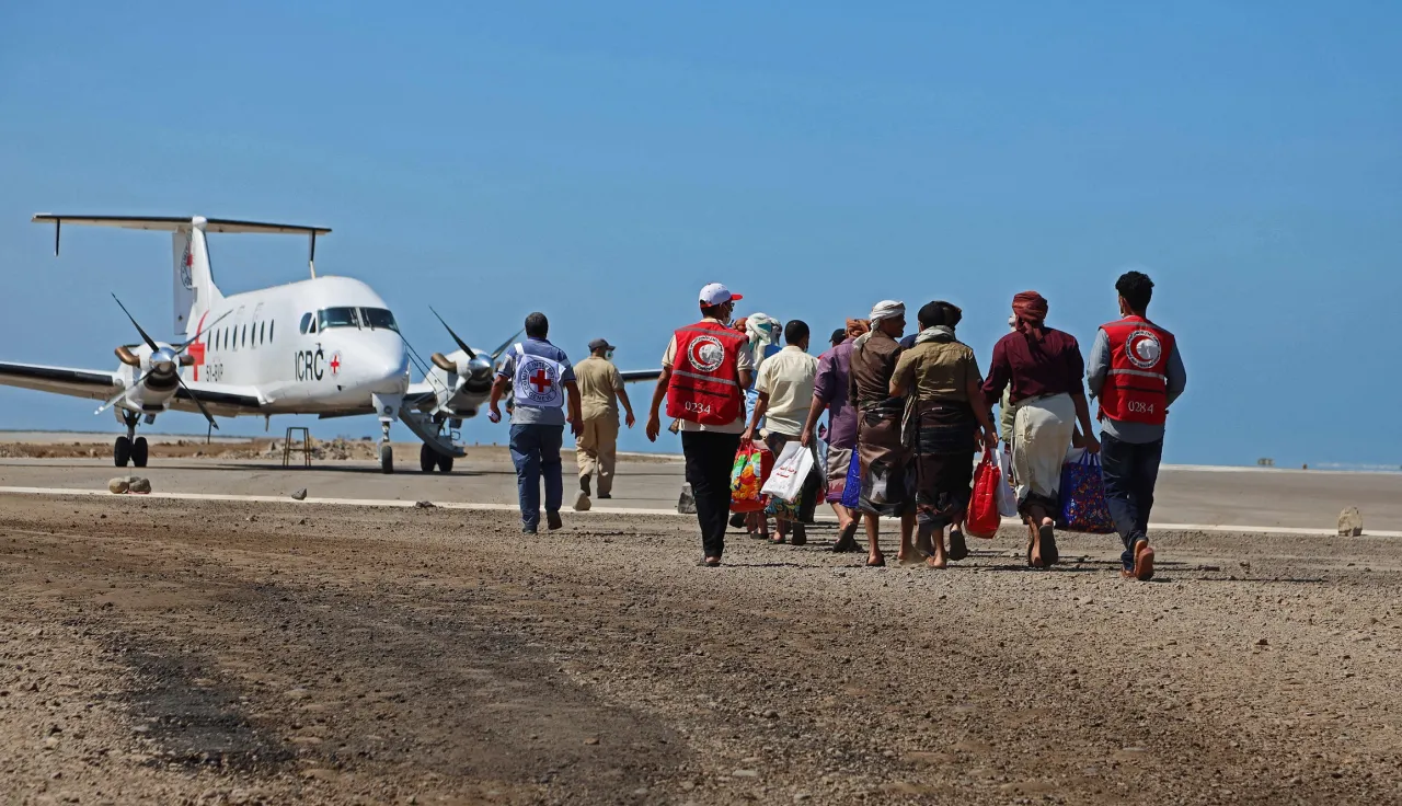 several people walking toward an ICRC airplane in a air field